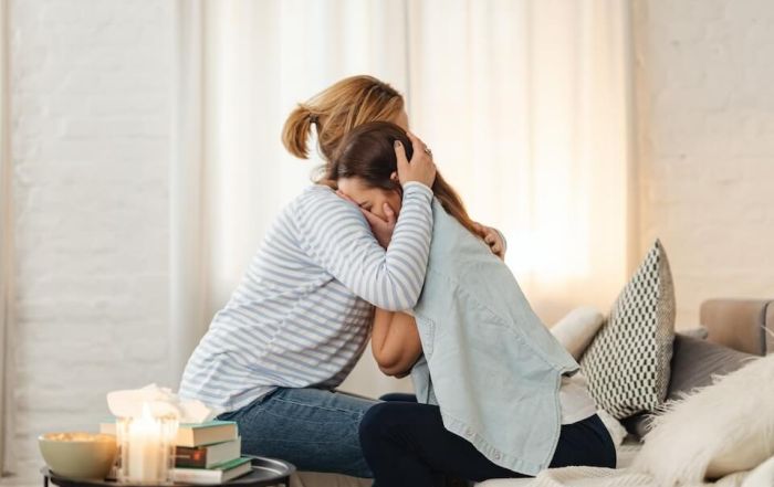 mother comforting crying daughter